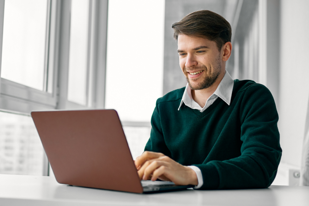 Einkäufer am Laptop prüft Lieferanten-Website eines Fertigungsunternehmens